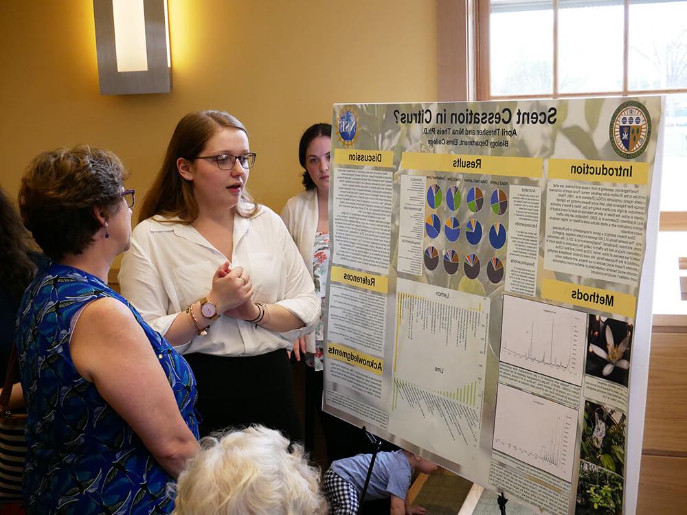 Photo of ElmSTEM scholar April Thresher presenting a research poster.